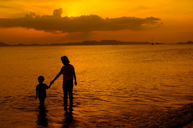 Una madre e hijo en al aire libre al atardecer con espacio de copia