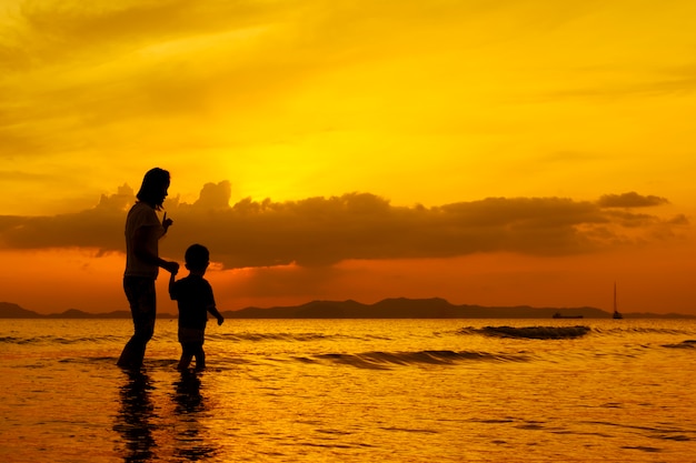 Una madre e hijo en al aire libre al atardecer con espacio de copia