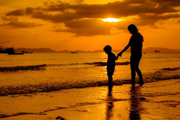 Una madre e hijo en al aire libre al atardecer con espacio de copia