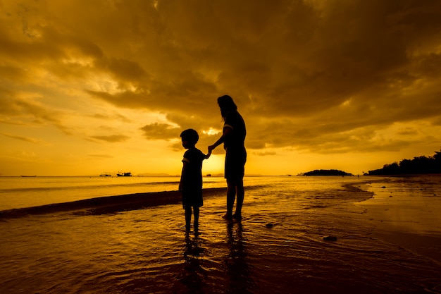 Una madre e hijo en al aire libre al atardecer con espacio de copia