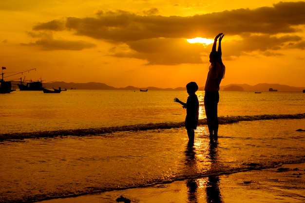 Una madre e hijo en al aire libre al atardecer con espacio de copia