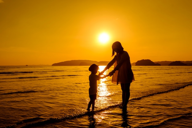 Una madre e hijo en al aire libre al atardecer con espacio de copia