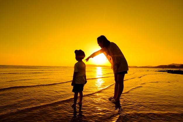 Una madre e hijo en al aire libre al atardecer con espacio de copia