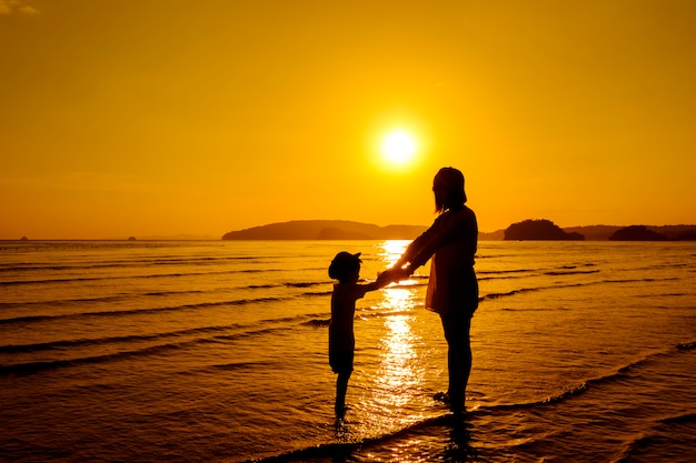 Una madre e hijo en al aire libre al atardecer con espacio de copia