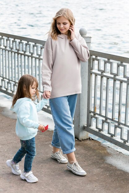 Madre e hijo caminando por la orilla del mar