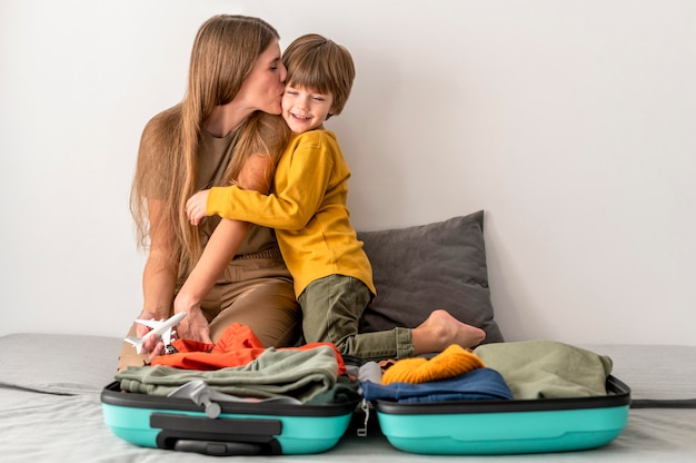 Foto gratuita madre e hijo en casa con equipaje