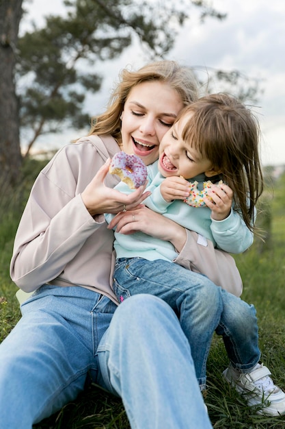 Foto gratuita madre e hijo comiendo donas