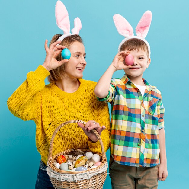 Madre e hijo cubriendo los ojos con huevo pintado