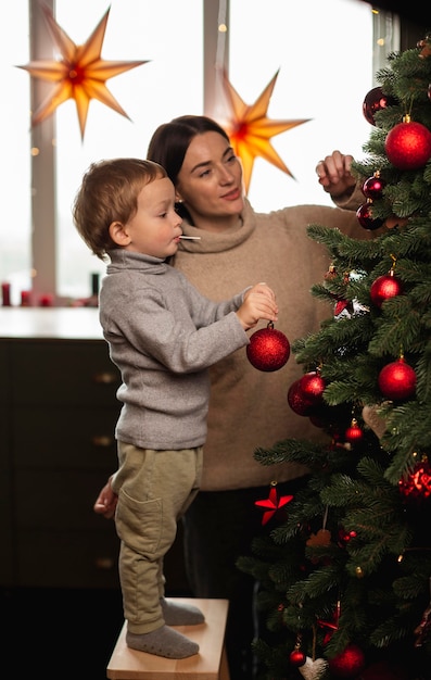 Madre e hijo decorando el árbol de navidad