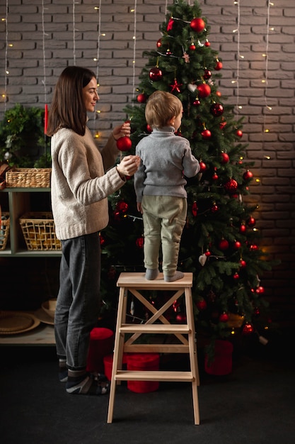 Foto gratuita madre e hijo decorando el árbol de navidad