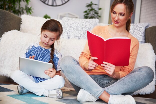 Madre e hijo enfocados estudiando con tecnología.