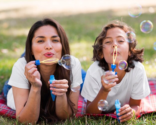 Madre e hijo haciendo globos juntos al aire libre