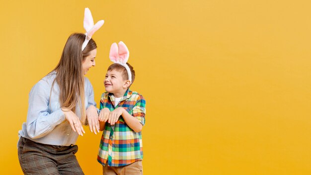 Madre e hijo imitando conejo con espacio de copia