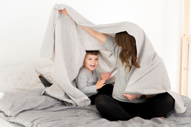 Foto gratuita madre e hijo jugando en la cama