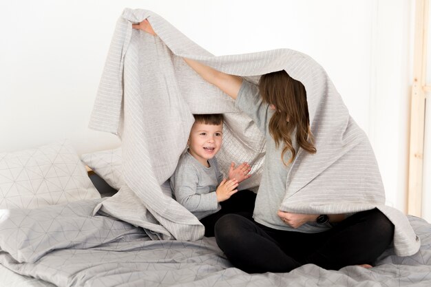 Madre e hijo jugando en la cama