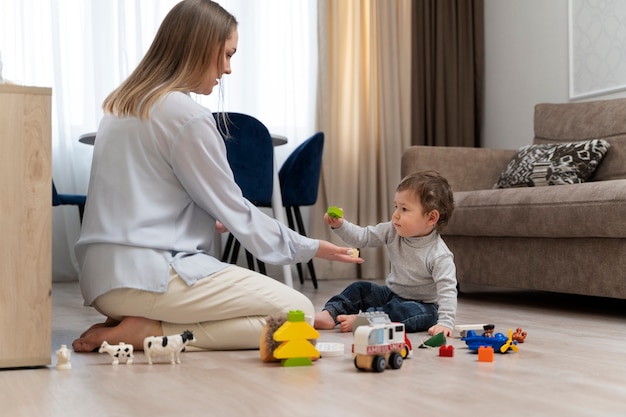 Madre e hijo jugando con juguetes tiro completo