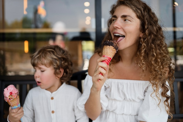 Madre e hijo lamiendo conos de helado vista frontal