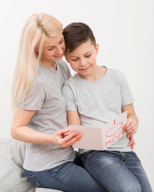 Foto gratuita madre e hijo leyendo la tarjeta de felicitación