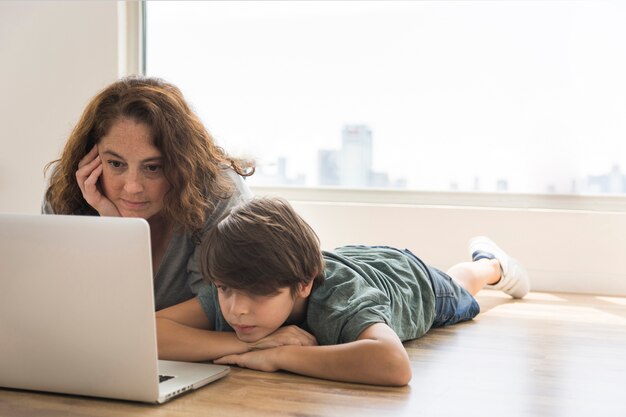 Madre e hijo mirando en la computadora portátil