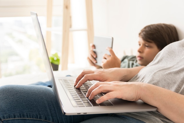 Madre e hijo mirando en dispositivos inteligentes