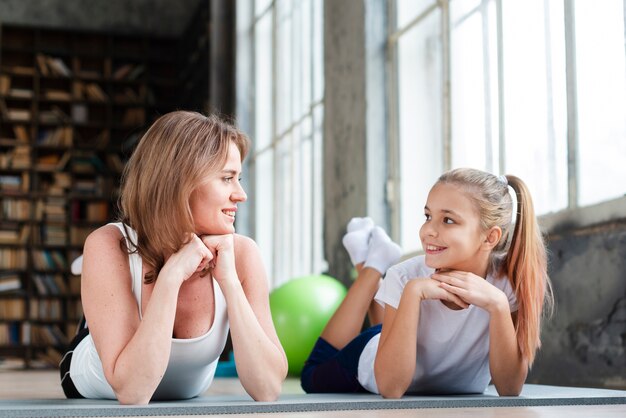 Foto gratuita madre e hijo mirándose en colchonetas de yoga