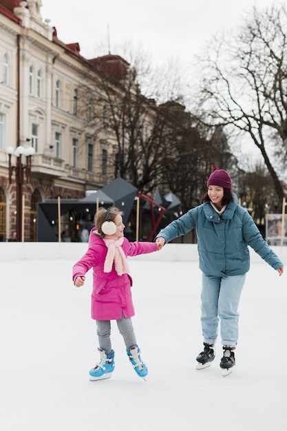 Madre e hijo patinar sobre hielo juntos