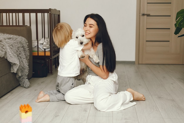 Foto gratuita madre e hijo pequeño divertido en casa con perro