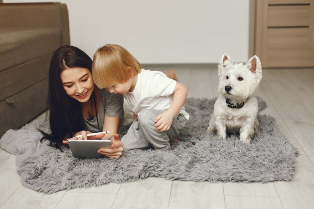 Madre e hijo pequeño divertido en casa con perro