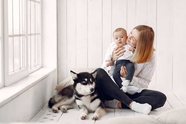 Madre e hijo pequeño jugando con perro en casa