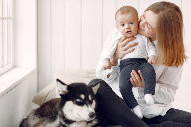 Madre e hijo pequeño jugando con perro en casa