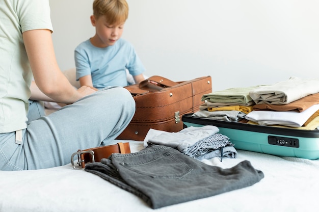 Foto gratuita madre e hijo preparando una maleta para sus vacaciones