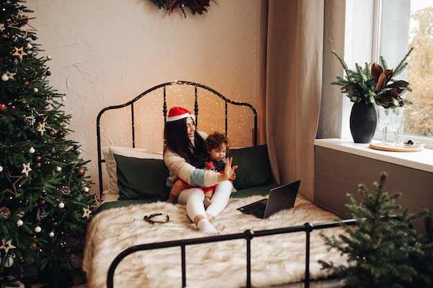 Foto gratuita madre e hijo saludando a través de una computadora portátil.