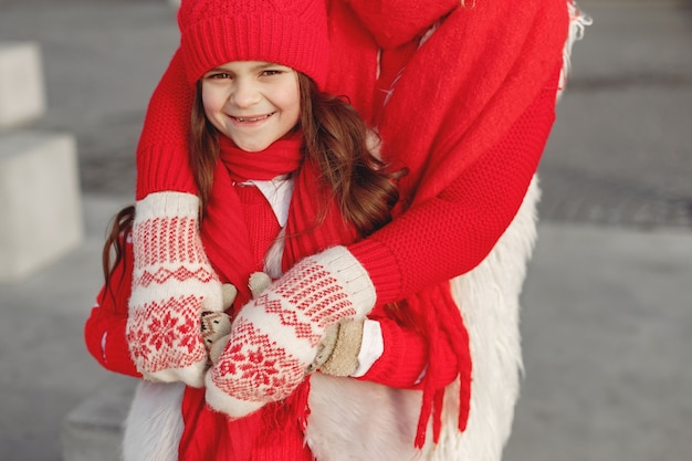 Madre e hijo con sombreros de invierno tejidos en vacaciones familiares de Navidad. Gorro y bufanda de lana hechos a mano para mamá y niño. Tejer para niños. Prendas de abrigo de punto. Mujer y niña en un parque.