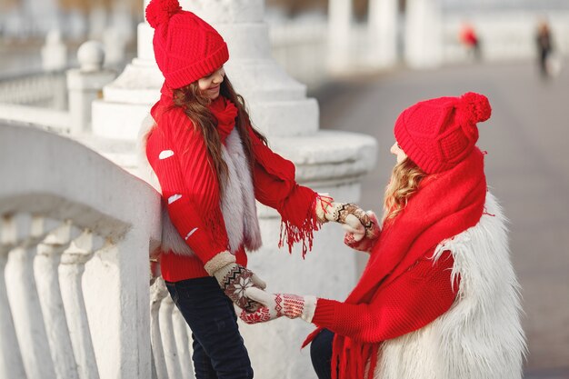 Madre e hijo con sombreros de invierno tejidos en vacaciones familiares de Navidad. Gorro y bufanda de lana hechos a mano para mamá y niño.