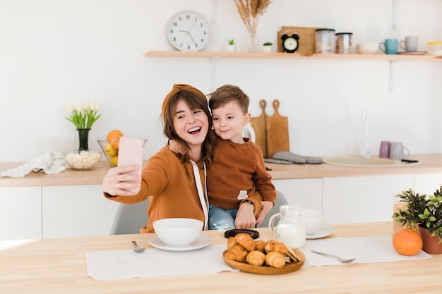 Madre e hijo tomando selfies en la cocina