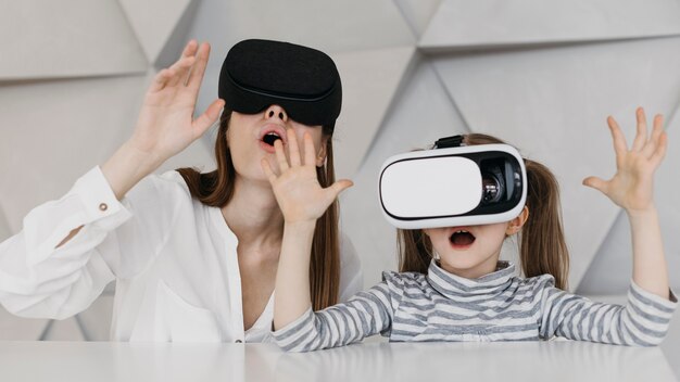 Madre e hijo usando casco de realidad virtual y asombrados