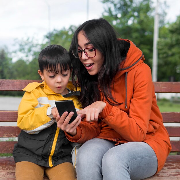 Madre e hijo usando el teléfono móvil