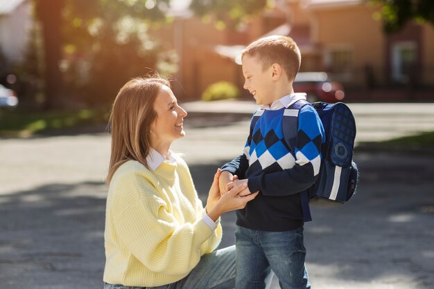 Madre e hijo en la vista lateral del primer día escolar