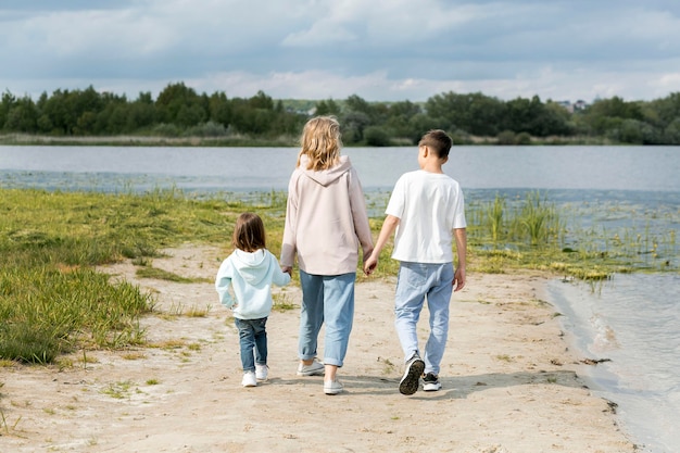 Madre e hijos caminando sobre la arena