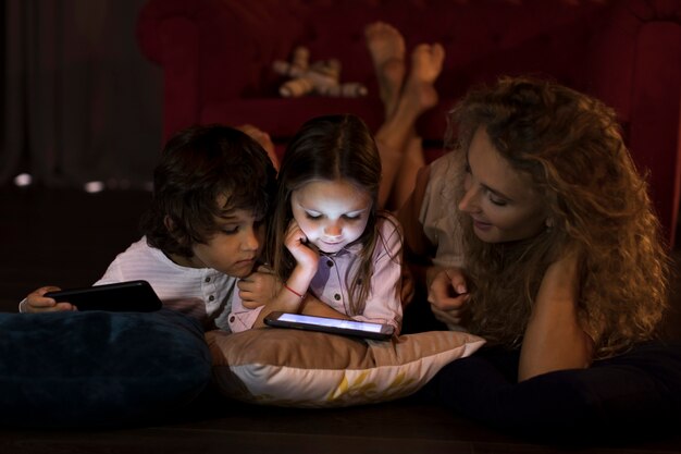 Madre e hijos jugando juntos en una tableta