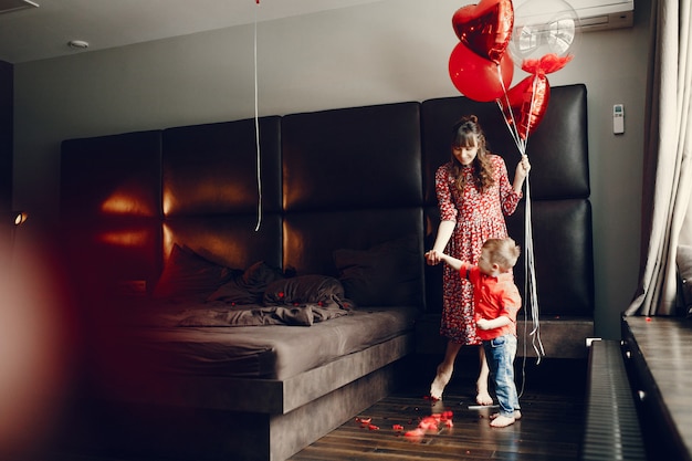 Madre elegante con pequeño hijo en una cama.