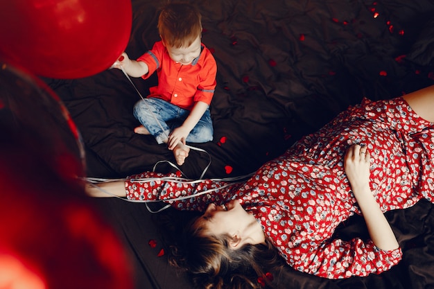 Madre elegante con pequeño hijo en una cama.