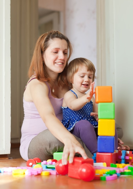 Madre embarazada juega con el niño