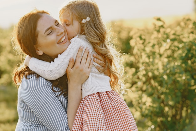 Madre embarazada con su hija en un campo