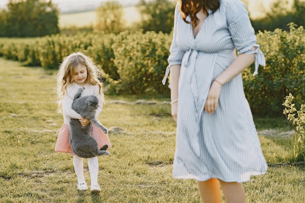 Madre embarazada con su hija en un campo