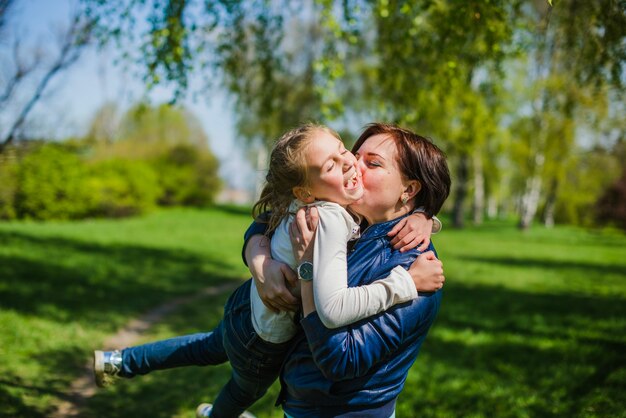 Madre encantadora besando a su hija