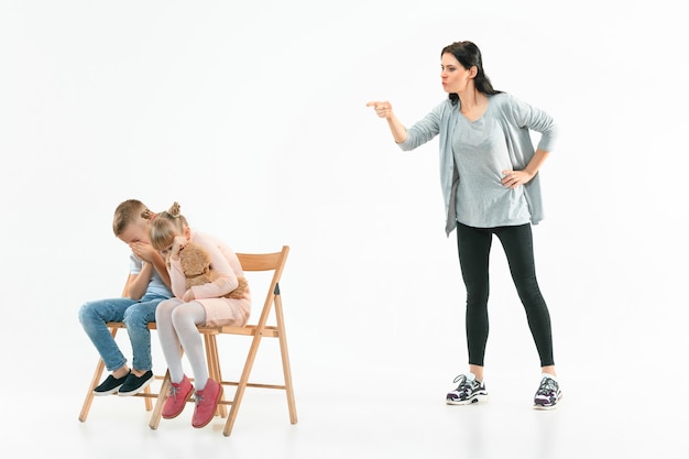 Foto gratuita madre enojada regañando a su hijo e hija en casa