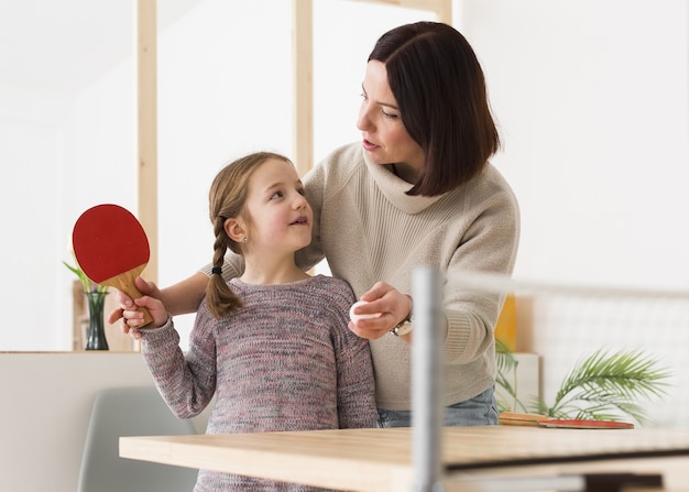 Madre enseñando hija ping pong