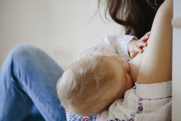 madre está amamantando a un pequeño bebé rubio