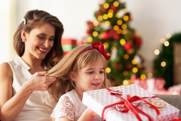 La madre está peinando el cabello de las niñas